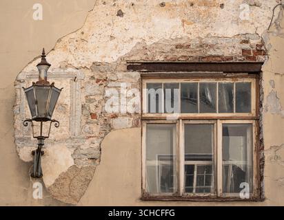 Historic weathered building facade with traditional lantern and old window in Tallinn Estonia Stock Photo