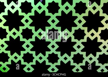 Close up of an islamic geometric pattern with green and black colors, creating a decorative surface Stock Photo