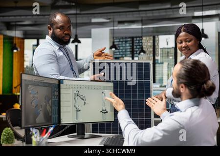 Engineering team doing brainstorming to optimize sustainable solar panel fabrication with advanced assembly lines. Teamworking colleagues innovate clean solar energy manufacturing processes Stock Photo