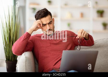 Pensive arab man working on laptop, looking for solution Stock Photo