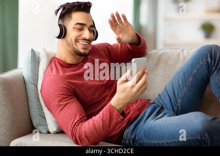 Cheerful arab guy having video chat, using mobile phone Stock Photo