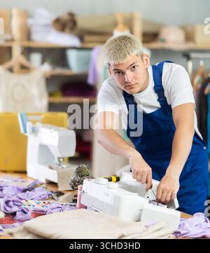 Repairman repairing sewing machine in workshop Stock Photo