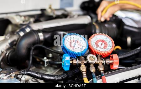Car air conditioner check service, leak detection, fill refrigerant.Device and meter liquid cooling in the car by specialist technicians. Stock Photo