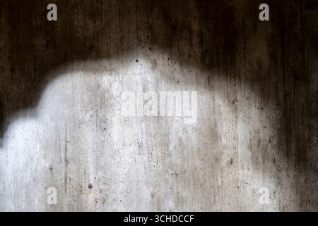 Abstract image of a grungy and aged cement surface. The texture features cracks and a shadow overlay. Copy space. Textured background Stock Photo