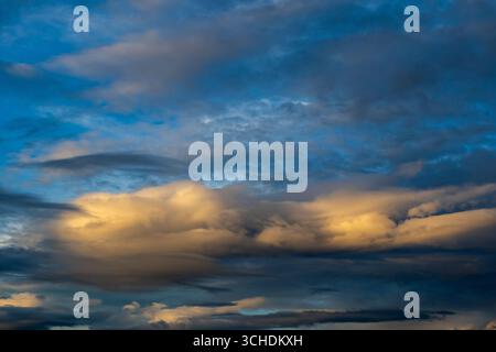 Golden clouds against a deep blue evening sky Stock Photo