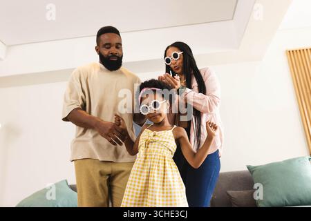 Happy couple wearing stylish sunglasses, having playful time together at home Stock Photo