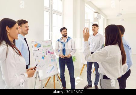 Business presentation in modern office, manager coaching writing, showing plan on whiteboard Stock Photo