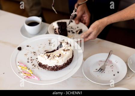 Sharing delicious chocolate cake and coffee with diverse friends at home, enjoying dessert Stock Photo