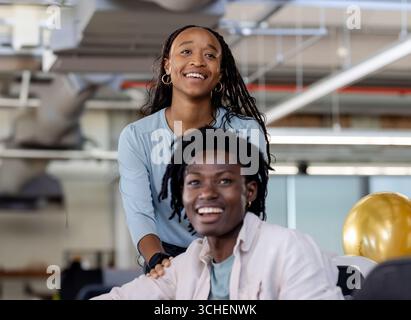 Diverse colleagues in modern office smiling and collaborating on creative business project Stock Photo