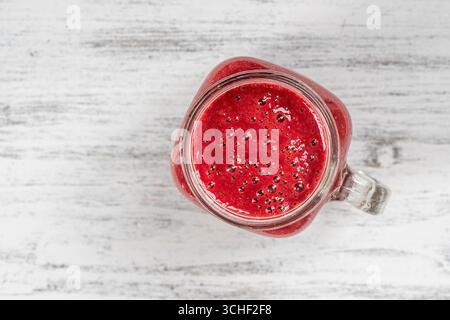 Fresh organic red smoothie in glass mug on white table, close up, top view. Refreshing summer fruit drink. The concept of healthy eating. Blackberry, Stock Photo