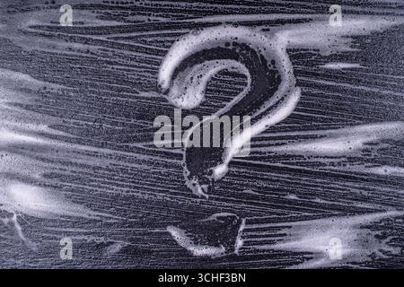 Question mark made from soap foam on a black background. Abstract foam texture on black background. Soap foam bubbles abstract dark background , top v Stock Photo