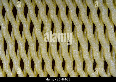 Abstract background of yellow plastic mesh texture for fruit storage, close up Stock Photo