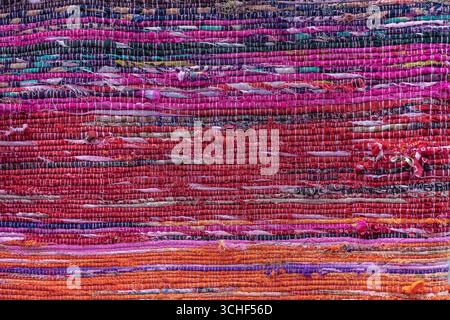 Cloth, typically produced by weaving or knitting textile fibers. Background and texture red old fabric. Close up Stock Photo
