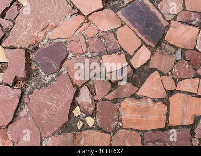 Close-up of a cobblestone road paved with red marble (or granite). Background. Stock Photo