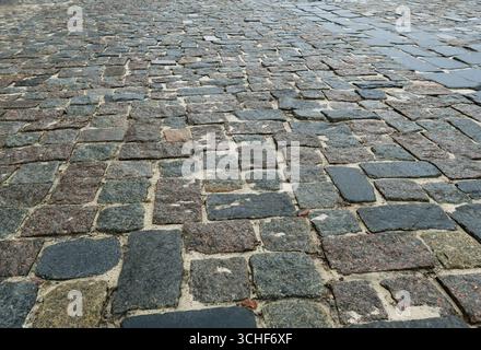 Close-up of a road paved with large granite cobblestones. Background. Stock Photo