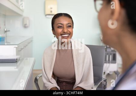 Woman patient laughing, feels satisfied with consultation in private clinic Stock Photo