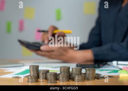 Close-up of a businessman’s hand pressing calculator buttons while calculating expenses at work, concept of finance, accounting, and cost management Stock Photo