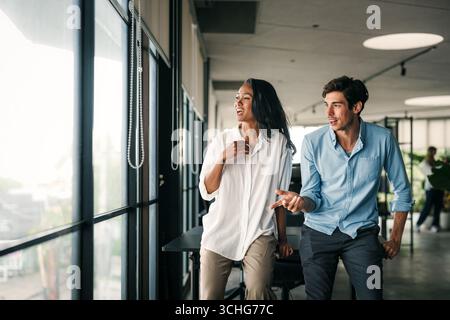 Cheerful diverse coworkers having fun during work break using technology enjoying working together Stock Photo