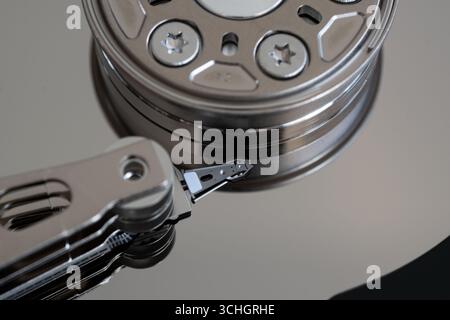 Close up of parts inside hard disk drive, actuator arm with read/write head and spindle holding platters Stock Photo