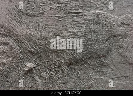 Close-up of a textured gray wall, exhibiting rough, uneven surfaces with intricate patterns and subtle color variations. Stock Photo
