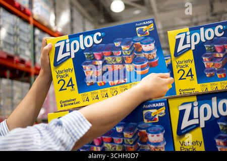 A shopper gets a box of Ziploc Variety Pack of 24 food storage containers from the grocery shelf. Stock Photo