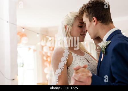 Bride and groom sharing intimate dance, celebrating love at wedding reception Stock Photo