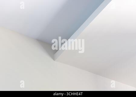 Minimalistic architectural detail featuring intersecting white and blue planes, capturing modern geometry with soft natural lighting that emphasizes c Stock Photo