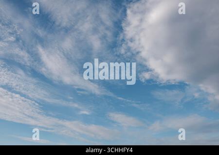 Clear bright sky with light white clouds drifting across a calm blue background. Perfect for nature designs, backgrounds, or copy space use in creativ Stock Photo