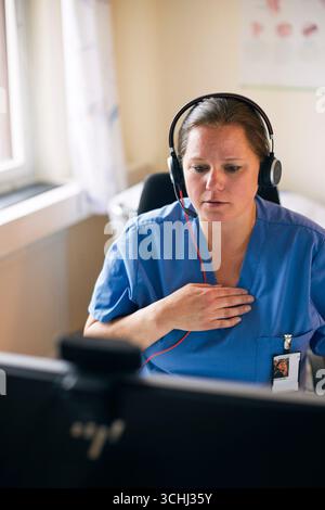 High angle view of female medical professional wearing headset giving online consultation in clinic Stock Photo