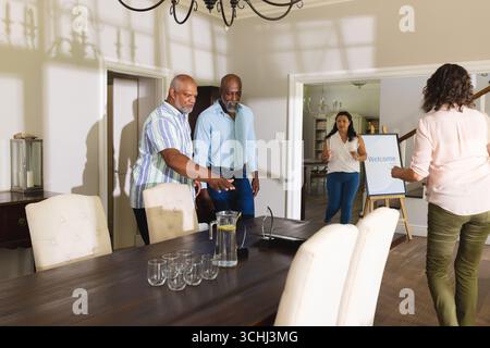 Senior men preparing for meeting at home, discussing plans with colleagues Stock Photo