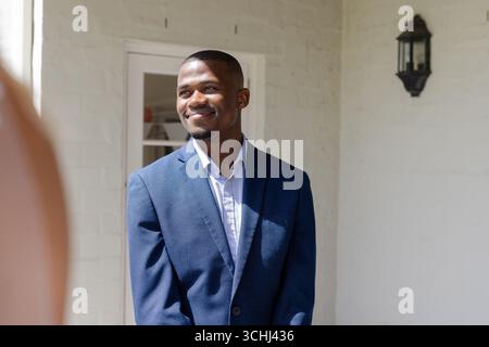 Smiling man in blue suit enjoying wedding celebration at elegant venue Stock Photo