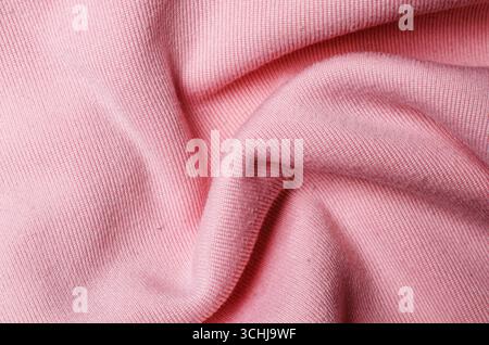 Wrinkled soft light pink polyester fabric creating textured textile background for modern fashion design and stylish interior concepts Stock Photo