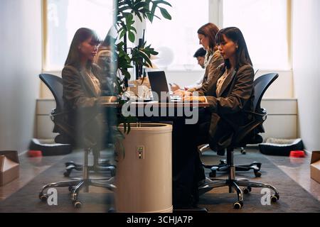 Concentrated female business entrepreneur working on laptop while sitting at desk in office Stock Photo