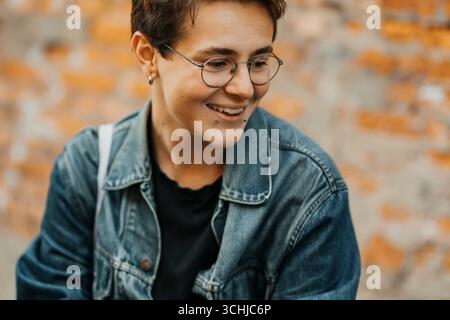 Smiling young man with piercing looking down Stock Photo