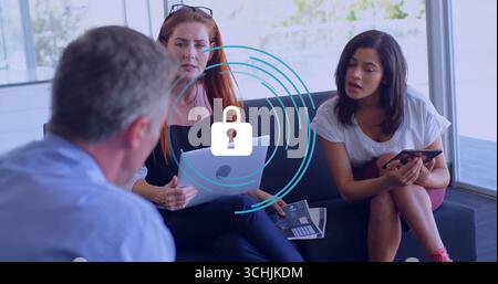 Collaborating professionals sitting on sofa in office lounge, using laptop smartphone with report Stock Photo