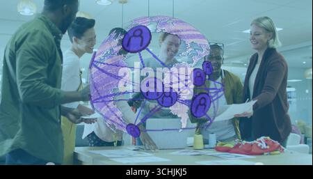 Team of six coworkers collaborating around table in meeting room, with purple globe and sketches Stock Photo
