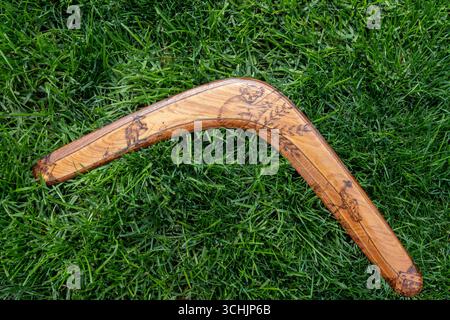 Close-up of a vintage 1970s wooden decorated boomerang from Australia on a Suburban Lawns in the United States. Stock Photo