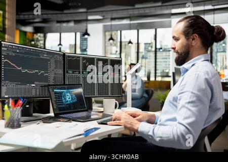 Trader running AI powered tools on laptop for automated trading and portfolio rebalancing. Man applying deep learning algorithms using notebook software to analyze complex market data Stock Photo