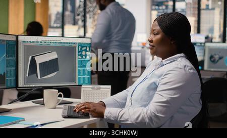 Engineer in office develops innovative solar powered device using advanced materials and designs. RD department expert creating solar gadget to improve environmental conservation efficiency, camera B Stock Photo