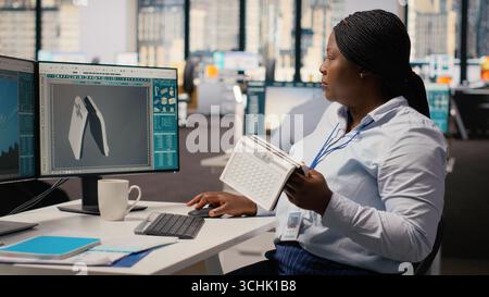 Product developer in office using advanced solar cell technology to create renewable energy based device. RD professional tests solar panel lamp prototype to maximize power output, camera B Stock Photo