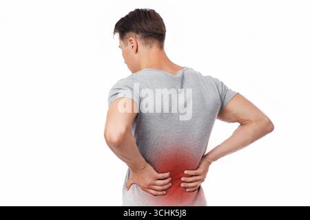 Young european man suffering from kidney pain, pressing his hand to back, isolated on white background Stock Photo