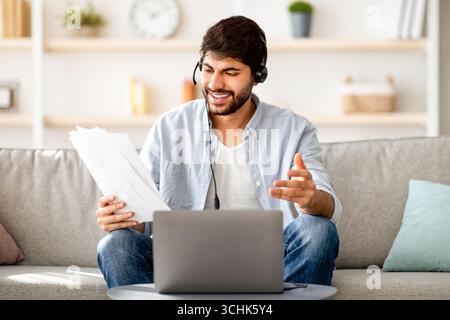 Virtual meeting. Confident arab businessman having video conference, working with financial documents online distantly Stock Photo