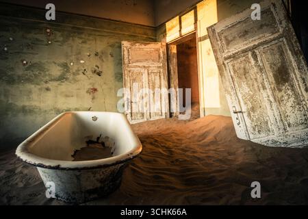 Abandoned bathtub in a decaying habitation of Kolmanskop Stock Photo