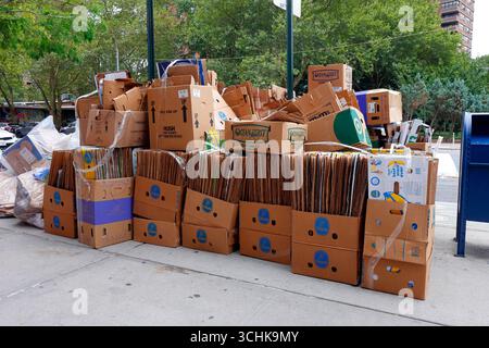 A large pile of discarded cardboard boxes placed curbside on a street in New York City for recycling. Stock Photo
