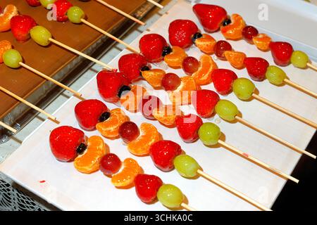 Tanghulu, candied skewered fruit, on a plate. Stock Photo