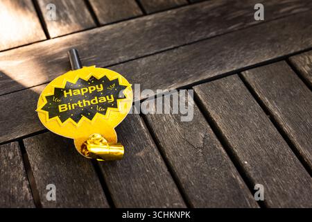 At party, birthday party badge on wooden table, ready for festive celebration, in garden, copy space Stock Photo