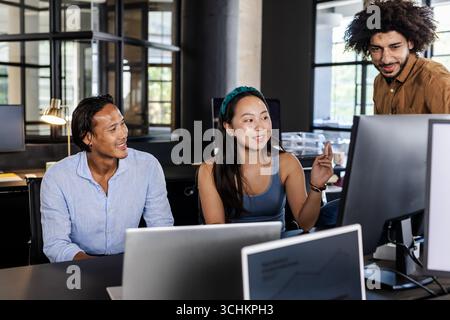 Collaborating in modern office, diverse team discussing project ideas enthusiastically Stock Photo