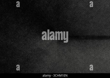 Old wrinkled fold of black rough cardboard sheet. Paper dark abstract background Stock Photo
