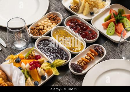Assorted breakfast platter with jams, fruits, nuts, and cheese Stock Photo