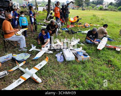 Group of people gathering outdoors with model airplanes, hobbyists preparing remote control. Yogyakarta, Indonesia - September 26th, 2021 Stock Photo
